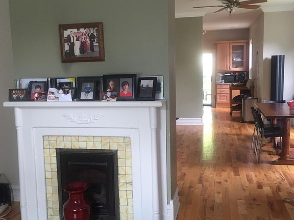 Living room with decorative fireplace open to spacious dining room and kitchen.