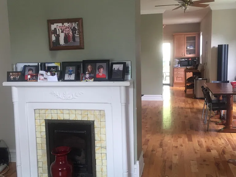 Living room with decorative fireplace open to spacious dining room and kitchen.