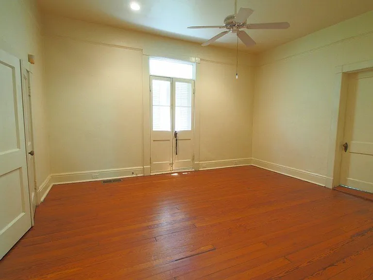 Front Bedroom with Walk In Closet, Hardwood floors, Recessed lighting, French Door to Balcony & Stair to Yard, Door to Bath