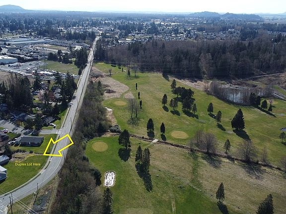Arial view of property shows golf course across the street.>