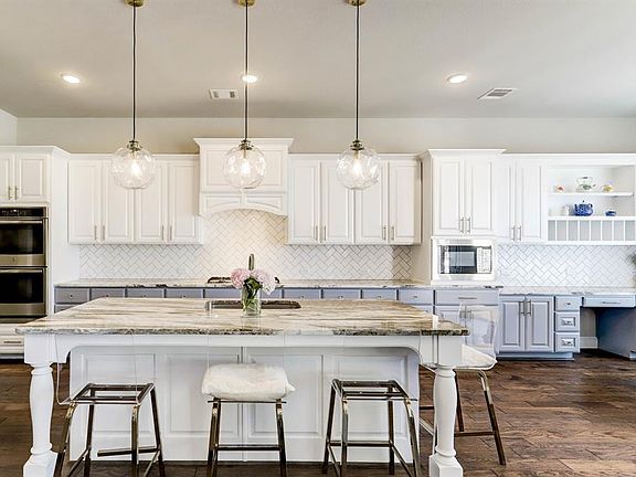 Light and bright kitchen features large island, custom lighting, double ovens, computer nook and breakfast room.