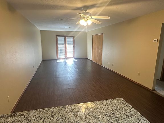 Open plan living room area with double wooden framed glass doors to patio