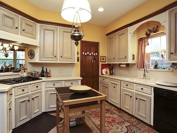 Charming kitchen, updated gas cooktop, wood grain tile floors, terrific pantry, and Silestone countertops