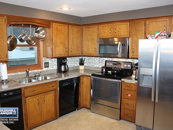 Kitchen with new refrigerator, stove, microwave, sink, and counter tops.