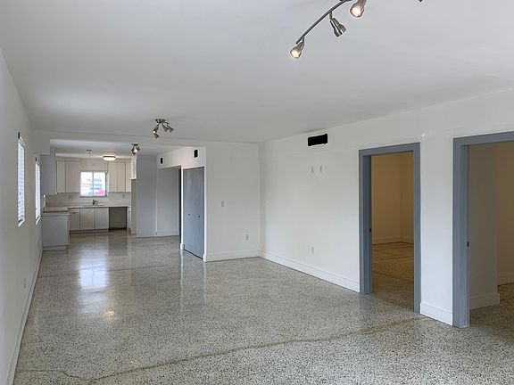 Living/Dining Room area with View of Kitchen and Private Bedrooms