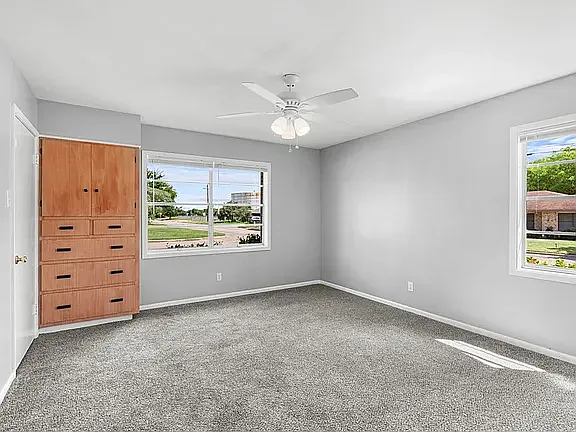 Front bedroom with built-in storage drawers, 2 deep closets, new gray carpet, ceiling fan, and fresh paint, very private with no common walls with other major rooms, except the Hall Bathroom.