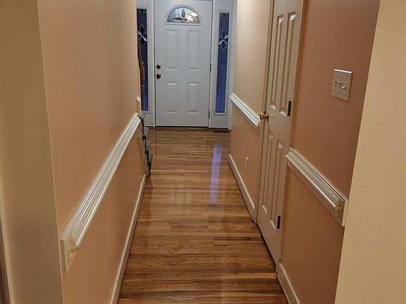 Foyer with hardwood floors and entrance to half bathroom