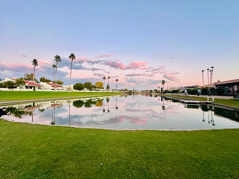 Breathtaking views of Lake Marguerite, serene water, swaying trees, lush lawns, and majestic mountains beyond...