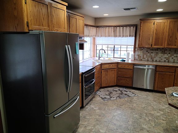 Spacious kitchen with large fridge, double oven, new dishwasher, garbage disposal and lots of cabinets and counter top space. Kitchen has a breakfast bar top area.