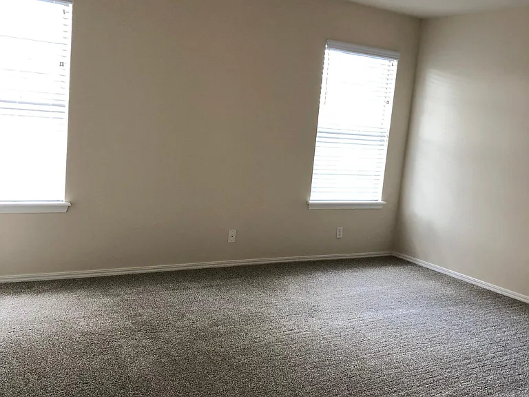 primary bedroom w/ tray ceiling and ceiling fan