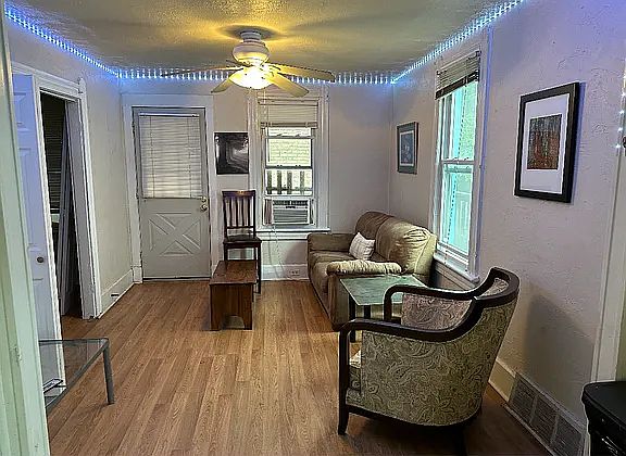 Living room with couch, comfortable chairs, and new ceiling fan