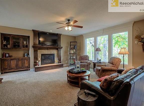 Spacious great room with tons of natural light and gorgeous dark wood fireplace surround and built-in cabinetry.