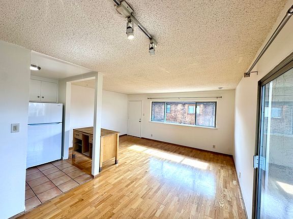 view of living space from hallway, sliding door to balcony at right.