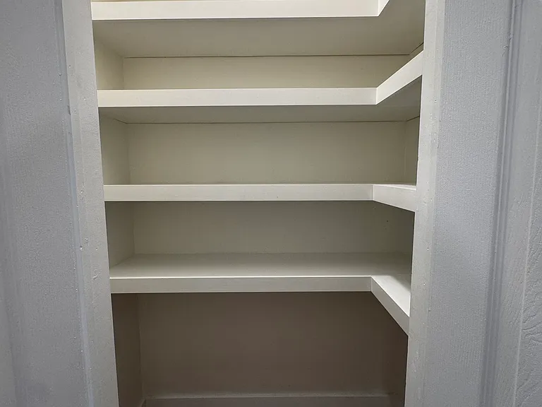 Walk-In Pantry (Actual Room): Spacious walk-in pantry with built-in shelving, offering abundant storage for groceries, small appliances, and household essentials while keeping the kitchen organized.