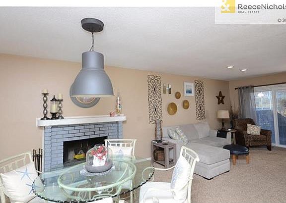 View from front foyer.  Living and dining room with gas fireplace.  Sliding doors lead to fenced in patio.