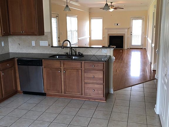 Large kitchen with granite counter tops and stainless steel appliance. Open floor plan to living area.