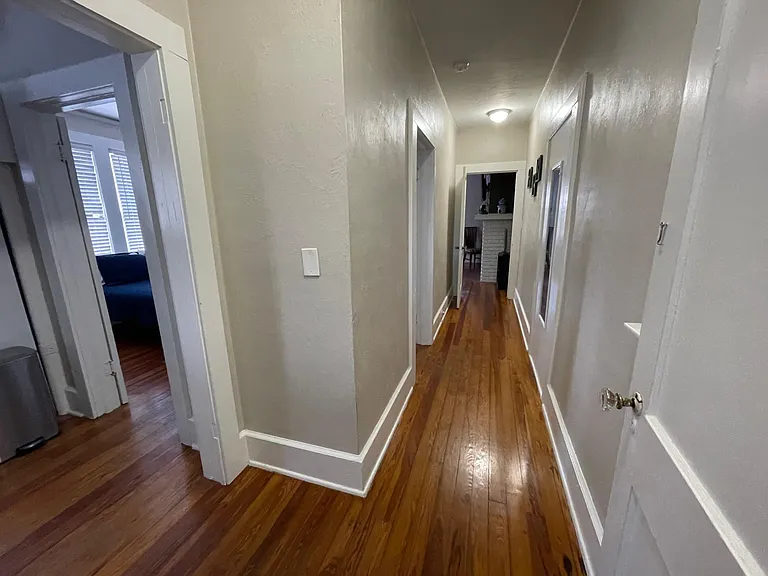 private hall to kitchen (on left which leads to bedroom), living room (on right) and bedroom (halfway down the hall).