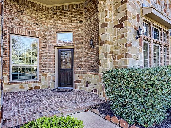 Stately entrance with brick pavers and beveled glass door.