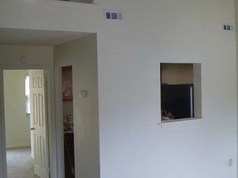 Entering into living room viewing kitchen on the right and back bedroom through doorway with view of upstairs bedroom.