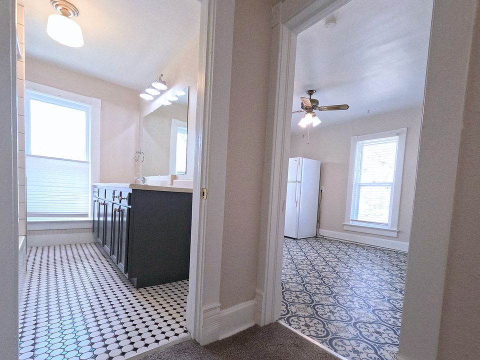 Standing in the hallway looking into the bathroom and kitchen.