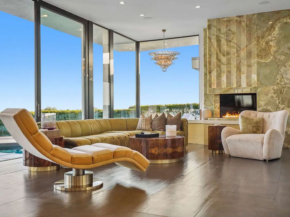 Plush seating, onyx fireplace, and expansive floor-to-ceiling windows with stunning views.