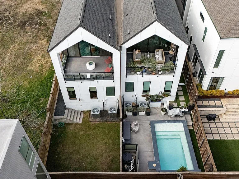 Modern white stucco duplex featuring private balconies with glass railings