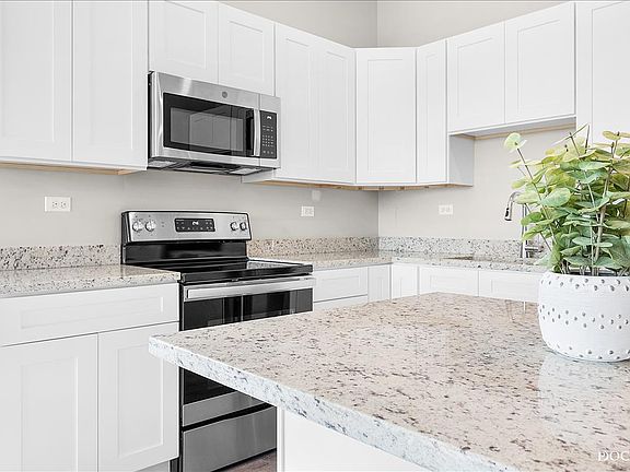 Modern kitchen with granite countertops, soft close cabinets, and stainless steel appliances. Fridge, range/oven, microwave, dishwasher, and garbage disposal included.