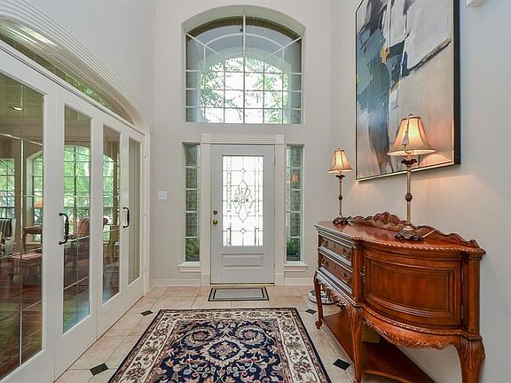 Two story foyer with tile flooring and accents. Beautiful leaded glass doors can close off the formals for more privacy.
