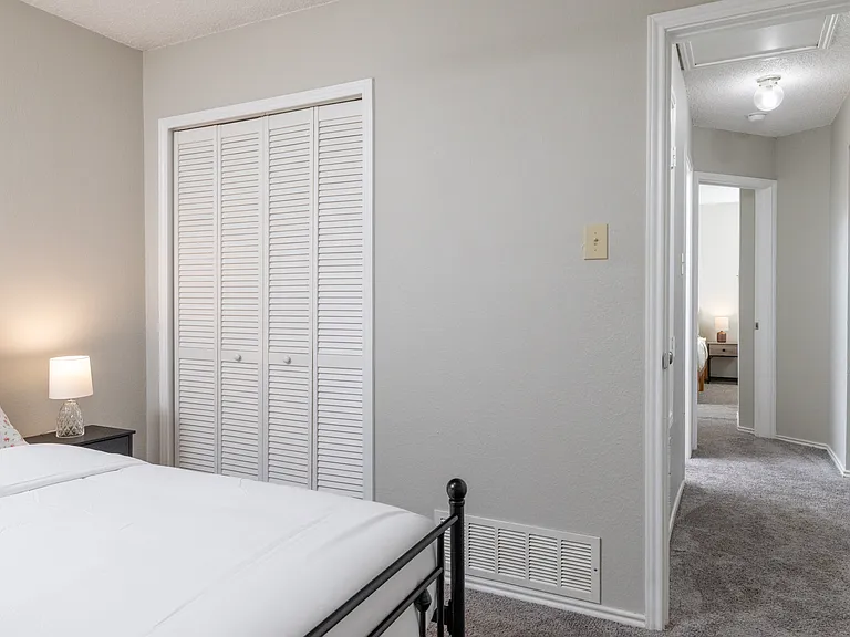 Upstairs Bedroom 2 offers a plush queen bed and cozy carpeted floors_ideal for a restful night's sleep.