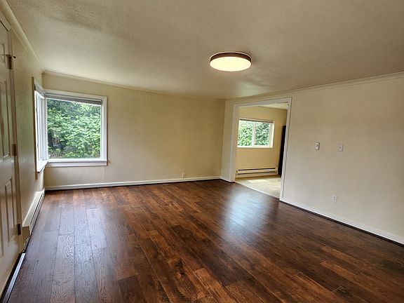 Another view of the living room. Property is surrounded by greenery on the side and rear.