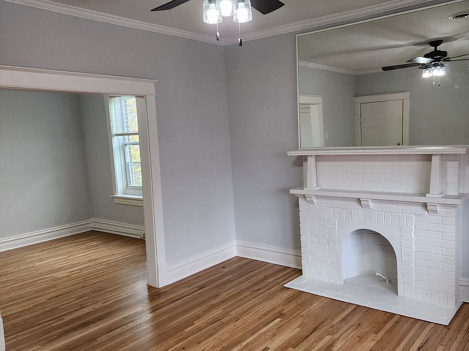 Front Room Looking into Middle Room with beautiful hardwood floors and modern ceiling fixtures and decorative fireplace
