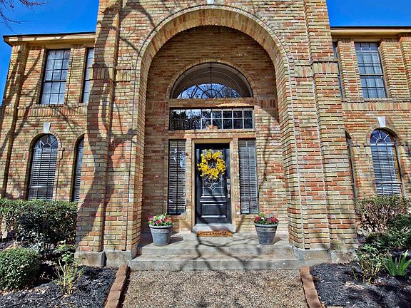 This home makes a statement... you know you are about to see somethings special as you step up to the porch under the bold, bric