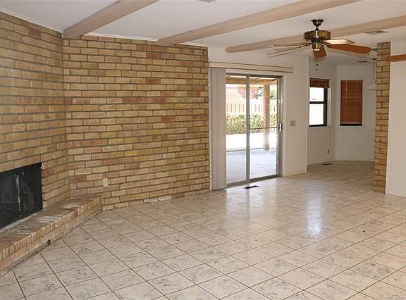 Family room has travertine floor and massive corner fireplace.