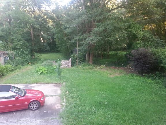 Expansive lawn with plantings and mature trees.