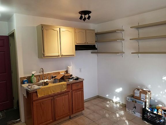 Kitchen marble counter top , shelves, moder sink and space for stove with precise lighting for better cooking.