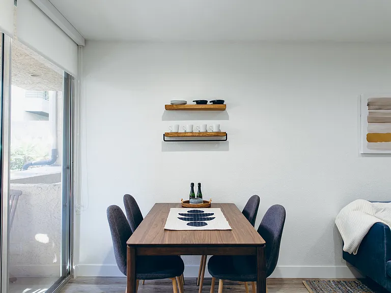 Dining area with wood-inspired floors, balcony on the left. Not all features are available in every apartments