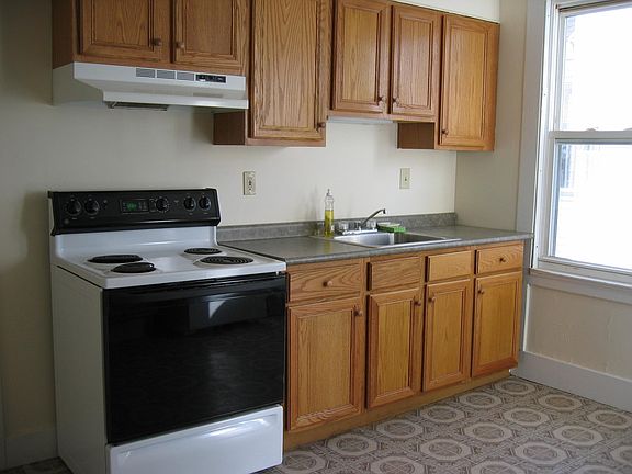 kitchen has electric stove and hood
