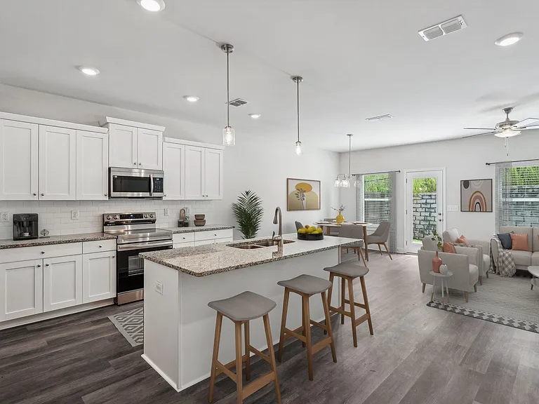 A modern kitchen showcasing a granite countertop island with bar seating and premium stainless steel appliances.