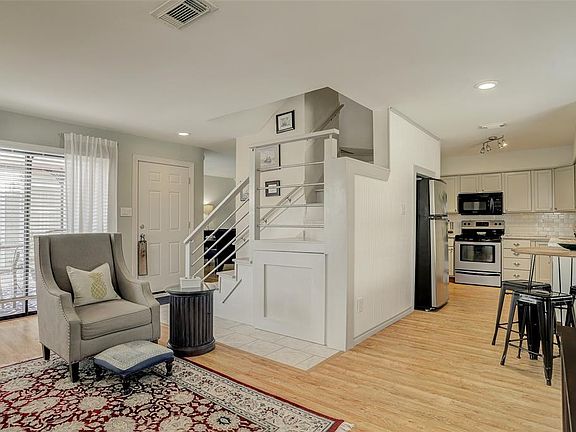 THE STAIRWAY HAS BEEN UPDATED WITH ALUMINUM RAILING AND WOOD TREAD FOR THAT UNIQUE TOUCH! OPEN DESIGN CONNECTS THE KITCHEN AND LIVING ROOM FOR EASY ENTERTAINING.