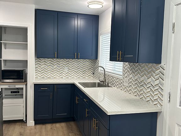 Newly renovated kitchen with new cabinets, counters, wood laminate floor