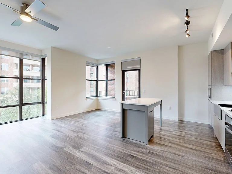 Apartment Kitchen with Stainless Steel Appliances, Dining and Living Room with Wood Style Flooring and Patio/Balcony.