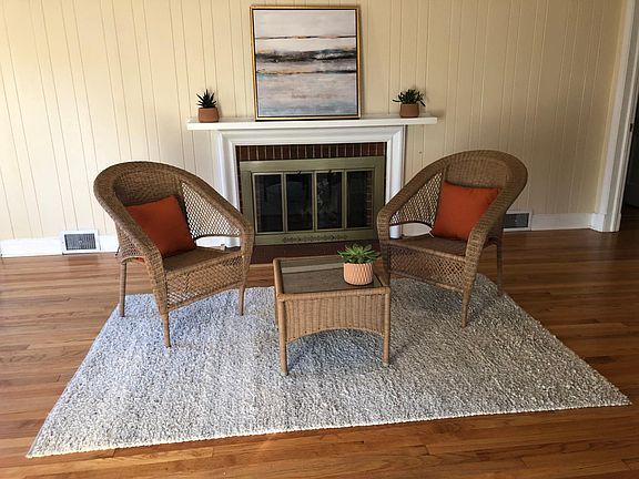 Welcoming family room with wood burning fireplace, beautiful hardwood floors and access to a three season enclosed porch.