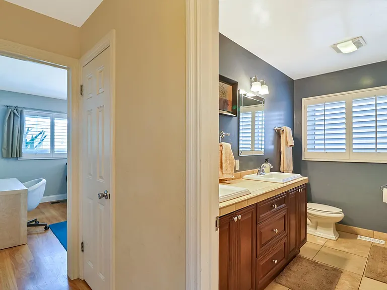 Hallway connecting main bathroom with second bedroom (linen closet door is pictured)