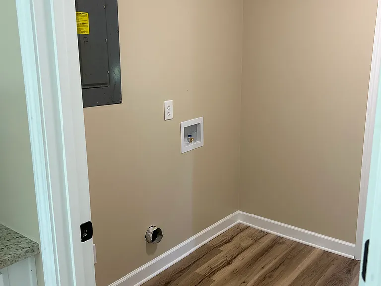 Laundry room off of kitchen area. Continues to mud room and garage.