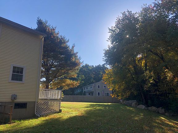 Backyard with view of large side yard and basement door access