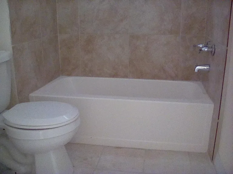 Redecorated 2nd Bathroom with tile flooring and tile walls