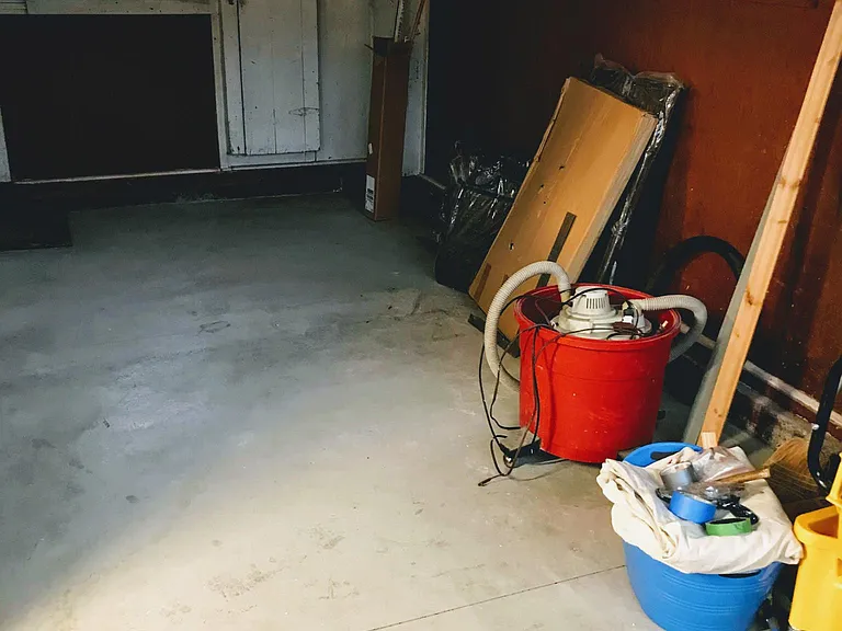 Enclosed (not heated) storage area with newly poured concrete floor with barn doors that lead to alley and man door to utility/laundry room.