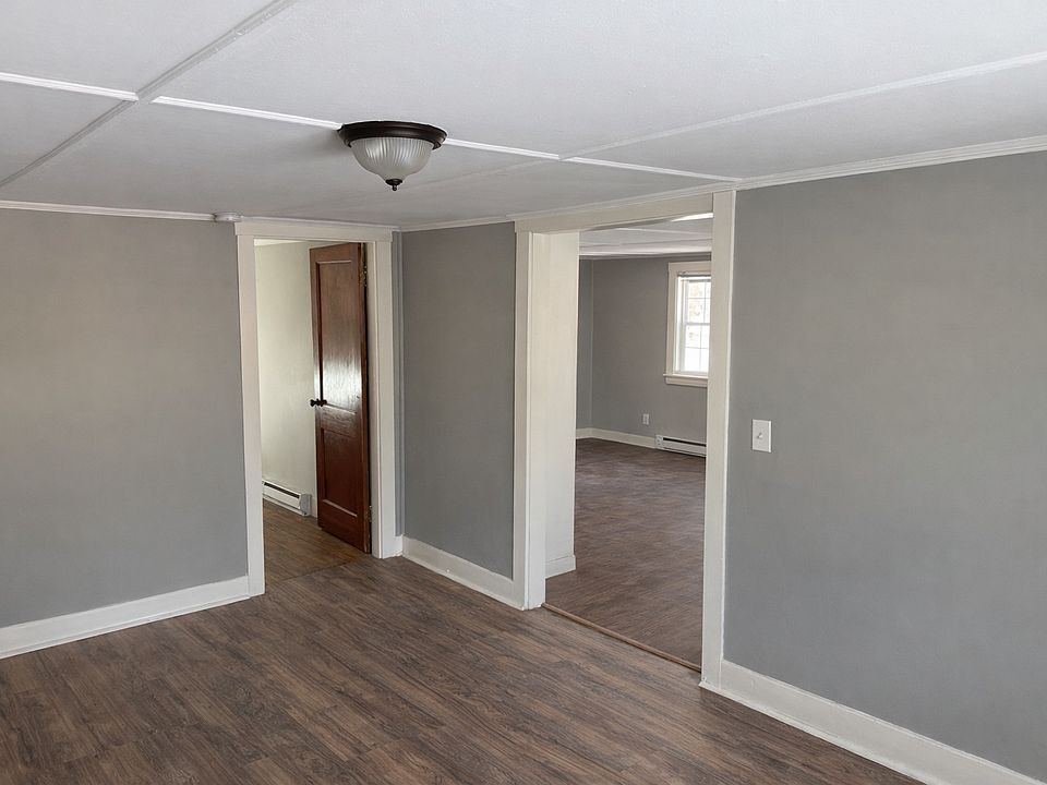 View from living room with bedroom in left rear and to kitchen / exit on the right