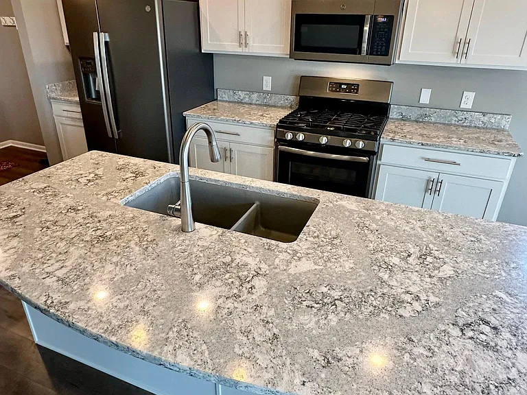 Large quartz center island with oversized double sink and garbage disposal