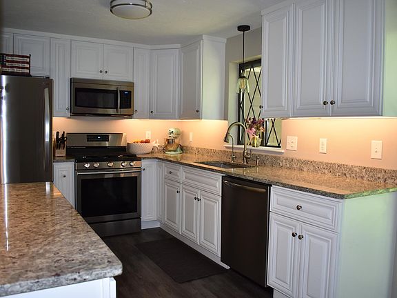 Kitchen with updated appliances, cabinets, and granite countertops.